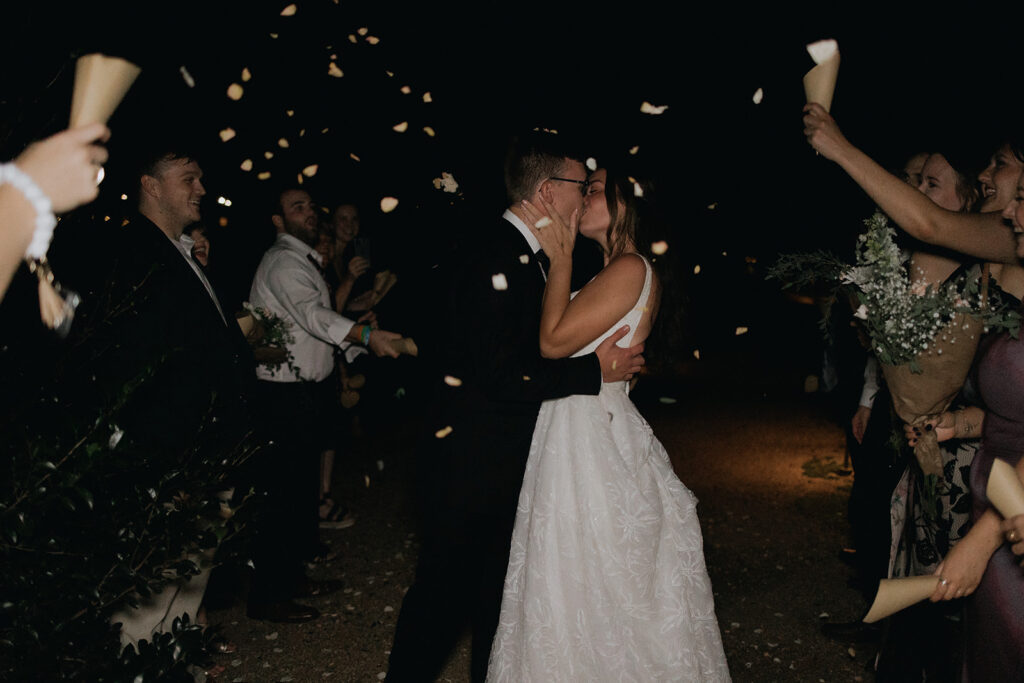 bride and groom exiting wedding with dried flower petals