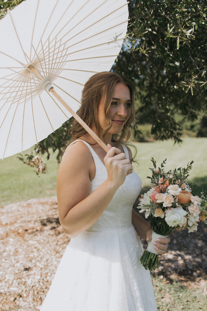 bride holding parasol in wedding dress at Morning Glory Farm
